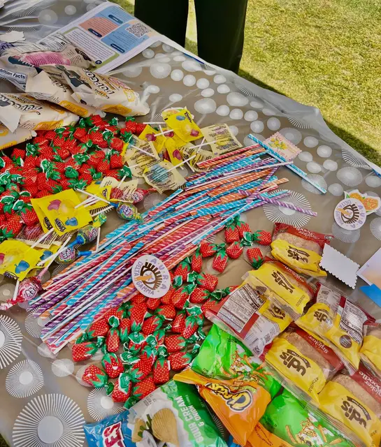 Sweets and decorated paper spread across a table on the campus lawn.
