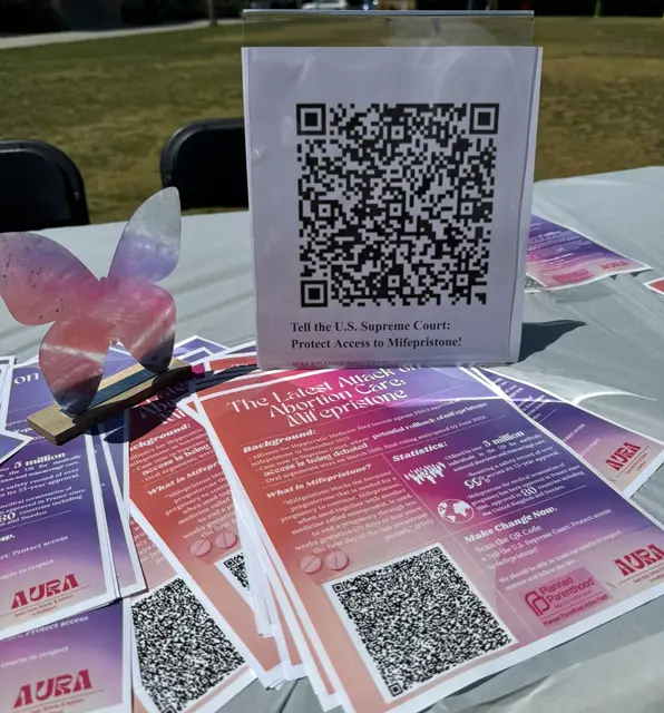 AURA flyers about medication abortion access and the Supreme Court, printed with QR codes.