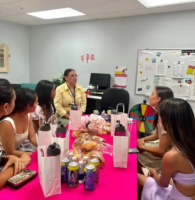 Students seated in a room with FPA Women's Health materials, gift bags and a prize wheel.