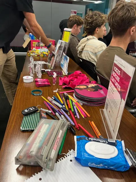 An information table laid out with pens, notebooks and printed cards for visitors.