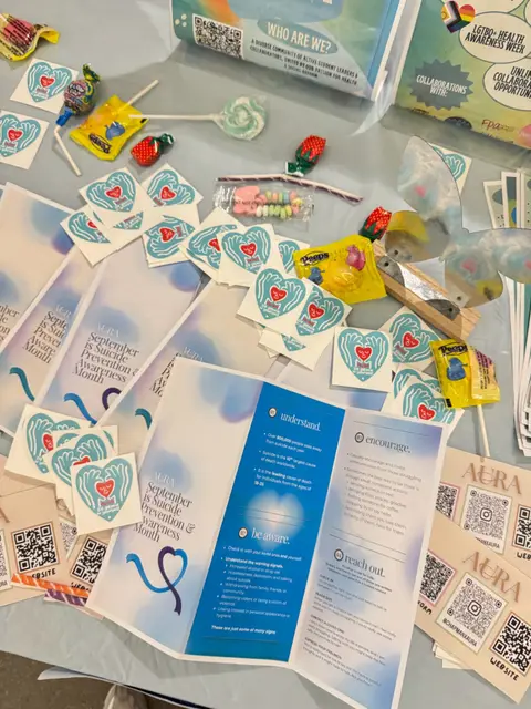 Heart-shaped stickers, QR code cards and a Planned Parenthood leaflet arranged on a table.