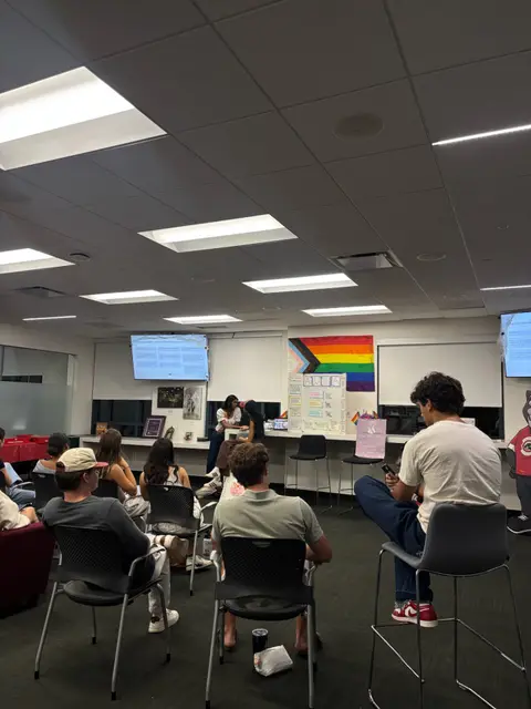 Students seated facing a presenter and screen during a club meeting.
