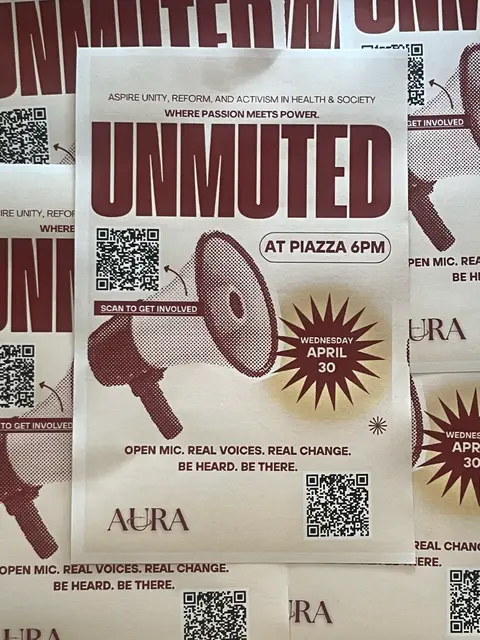A stack of posters for Unmuted, an open-mic night — "Open mic. Real voices. Real change."